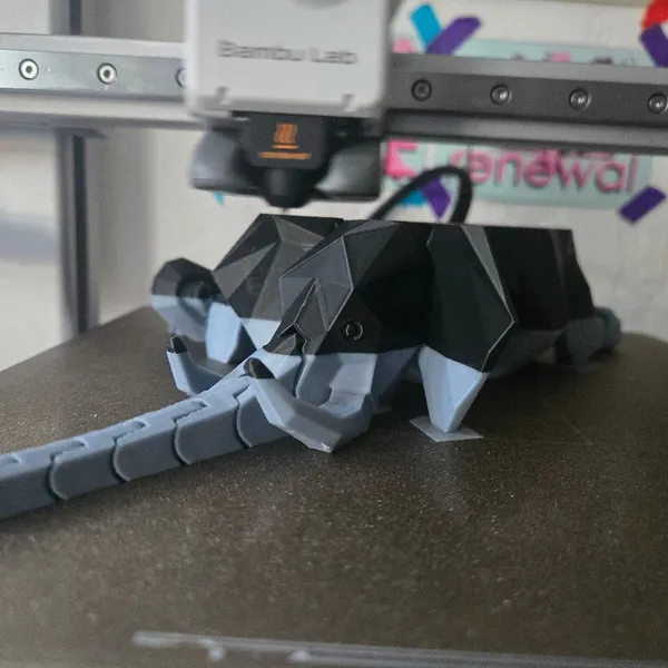 A Bambu Lab printer finishing a two-color articulated elephant