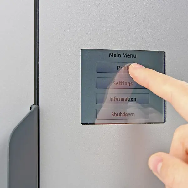 A finger pressing the main menu on a 3D printer's touchscreen, with Settings below