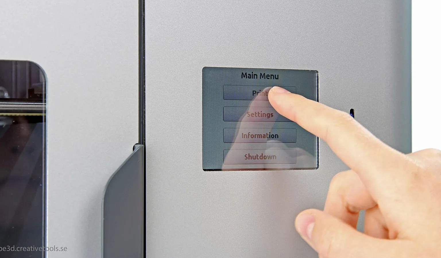 A finger pressing the main menu on a 3D printer's touchscreen, with Settings below