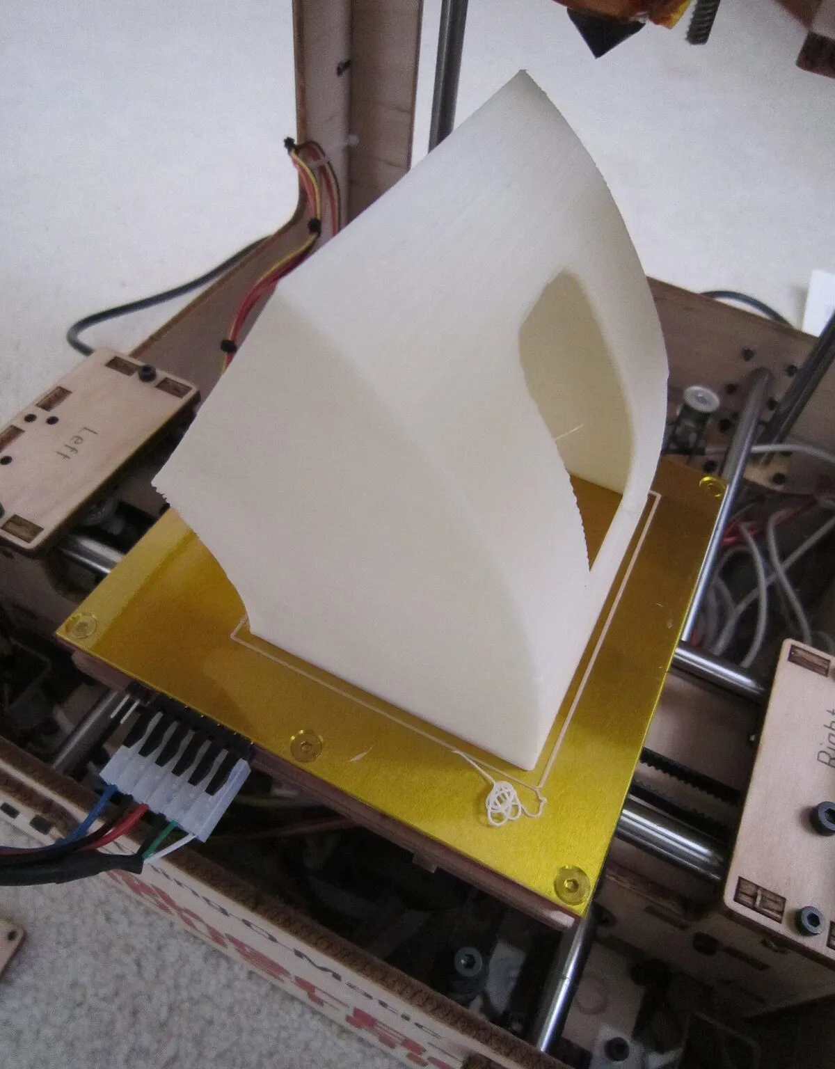 A finished white print being lifted off a printer's heated bed
