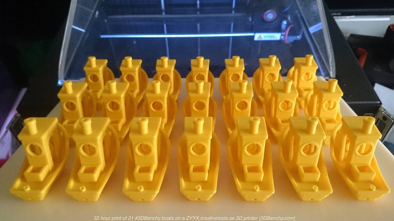 Twenty-one yellow 3DBenchy boats printed together on one build plate