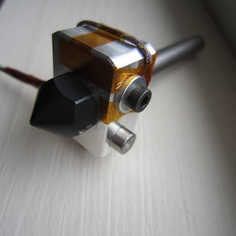 A hot end heater block with a temperature sensor held in place by Kapton tape