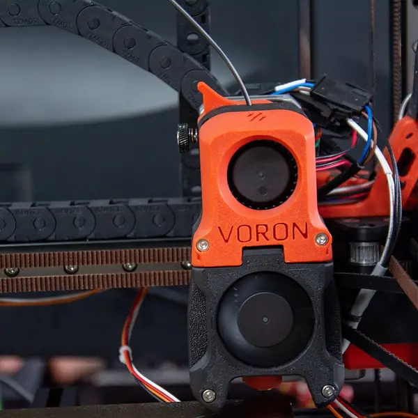 Front view of an orange Voron toolhead on its gantry, with the cable chain behind it