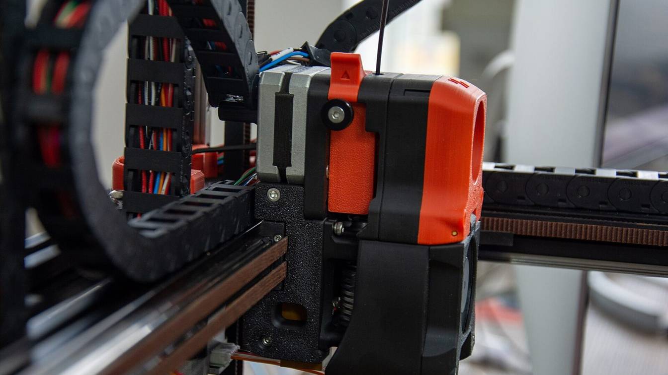 A Voron toolhead seen from the side, showing its extruder, wiring and cable chain