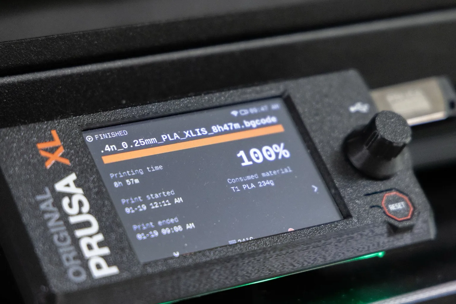 The control panel of an Original Prusa XL: a screen showing a finished 8 h 57 min PLA print using 234 g from tool T1, a control knob, a reset button and a USB drive
